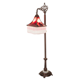 Victorian-style bridge arm lamp with burgundy glass shade lit.