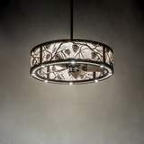 Whispering Pines chandelier fan softly illuminated in dark room.