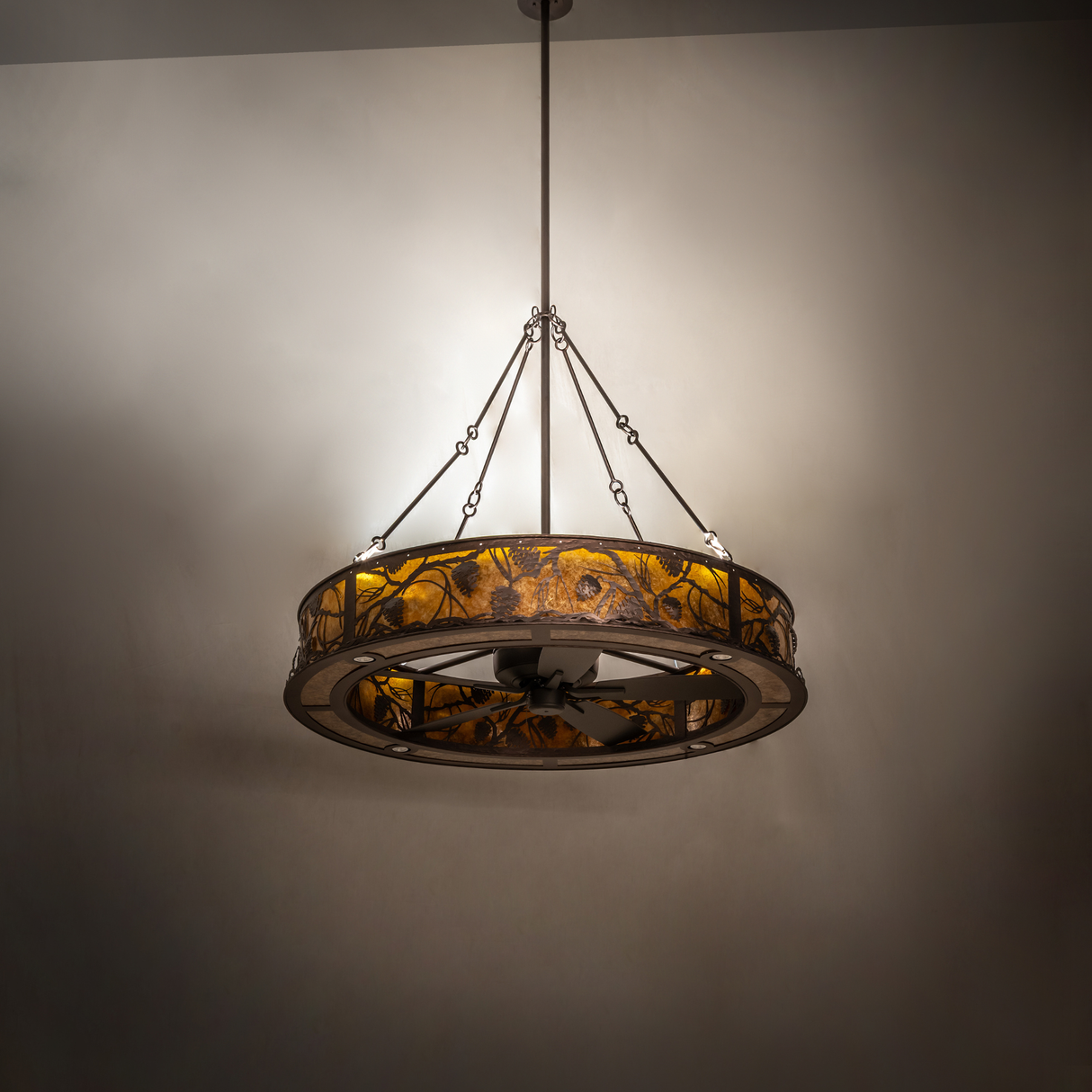 Angled view of illuminated Whispering Pines chandelier fan.