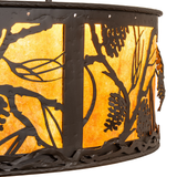 Close-up of handcrafted pinecone branch metalwork on amber mica shade.