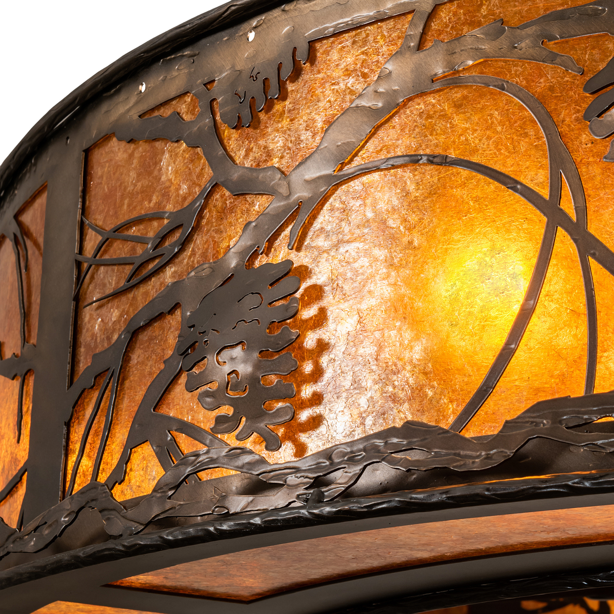 Close-up highlighting pinecone and branch cutouts on glowing amber mica.