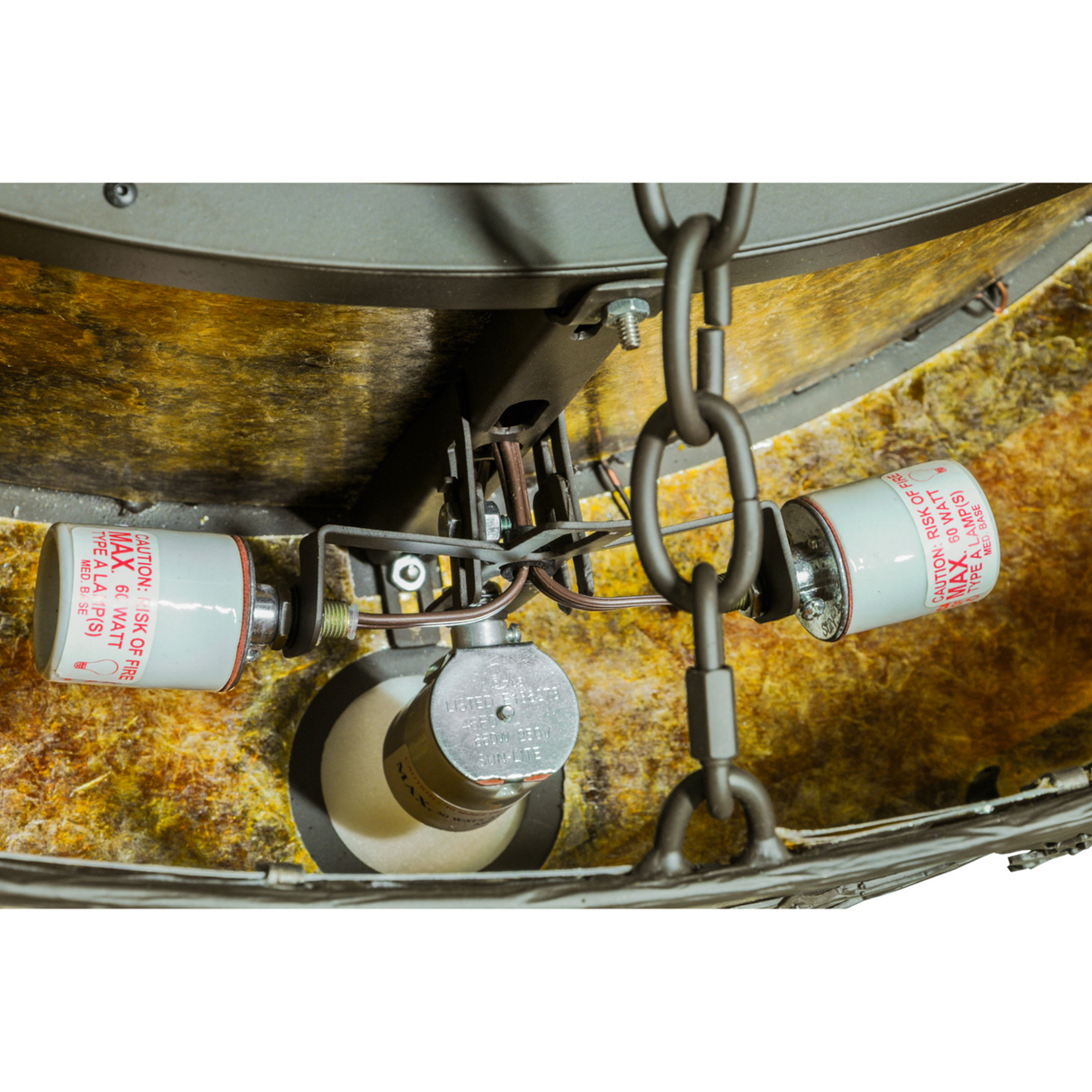 Closeup of bulb sockets and wiring against amber mica interior.