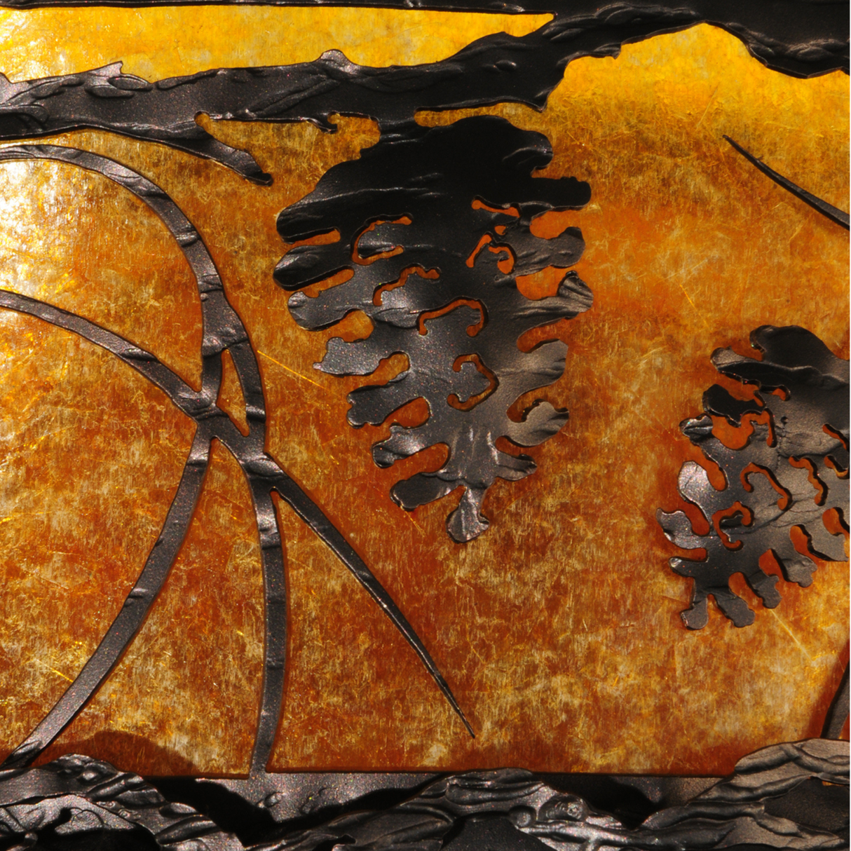 Pinecone detail close-up showing textured bronze overlay.