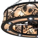 Close-up of Whispering Pines Chandel-Air shade with backlit pine motif.