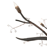 Detailed view of candle-style bulb and sculpted metal branch on chandelier.