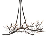 Lit view, showcasing glowing candle-style bulbs and sculptural metal branches.