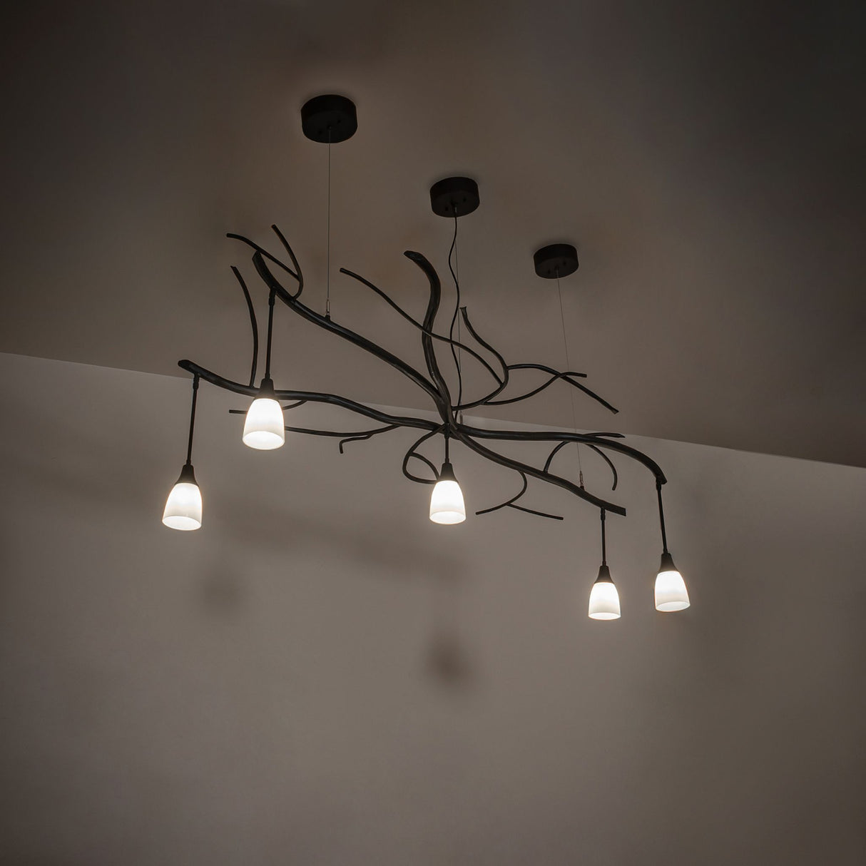 Ambient lighting over interior space highlighting organic branch-inspired metal design.