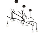 Unlit view of chandelier with sculptural branches and goblet-style glass shades.
